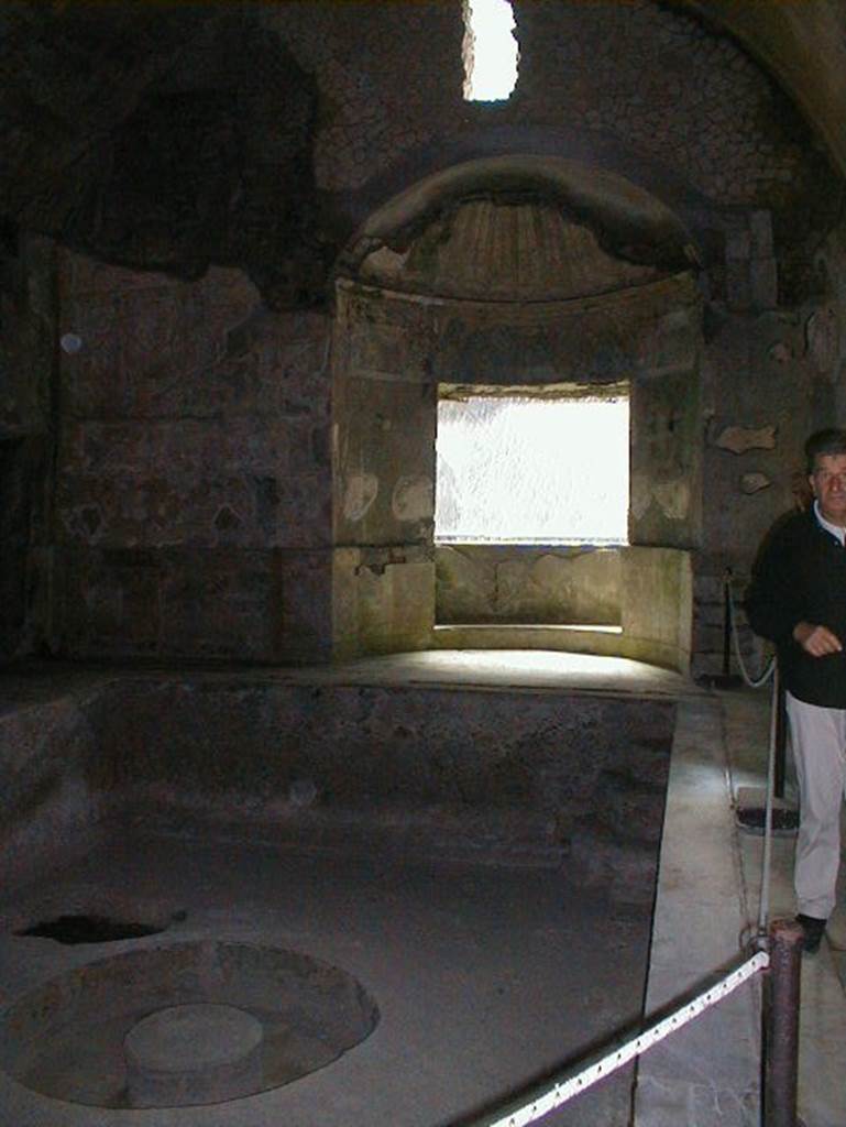 Suburban Baths, Herculaneum, May 2004. Second Caldarium, with large central bath and window overlooking the sea. Looking east. According to Wallace-Hadrill,
The original Baths were built with the standard areas of entrance hall, followed by cold, warm and hot rooms. This original Caldarium was small and intimate.
Then a second Caldarium was added, with its own furnace operating by direct heating immediately under the bronze “samovar” in the middle of the pool.
It offered an area of warm water big enough for up to twenty to swim in.
See Wallace-Hadrill, A., (2011): Herculaneum, past and future. London, Francis Lincoln Ltd., (p.159).